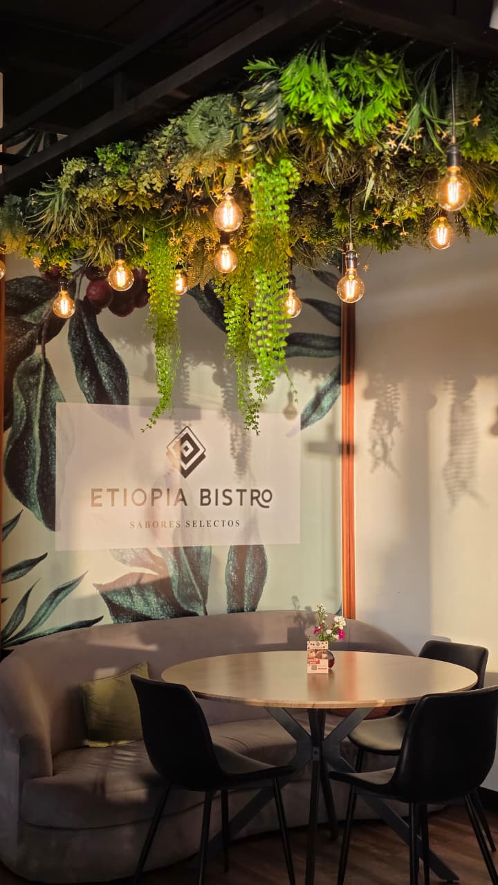 Mesa acogedora bajo el jardín colgante de Etiopía Bistro